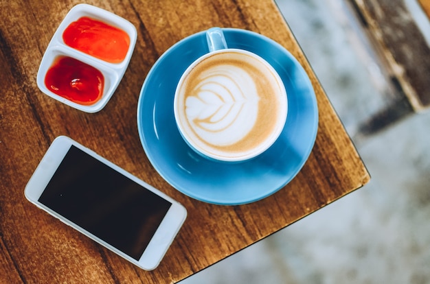 Draufsicht auf Cappuccino-Kaffee auf Holztisch