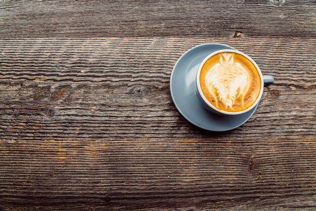 Draufsicht auf Cappuccino-Kaffee in weißer Tasse