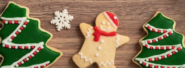 Draufsicht auf dekorierte Weihnachtslebkuchen mit Dekorationen auf Holztischhintergrund mit Kopierraum, Konzept der Feiertagsfeier.