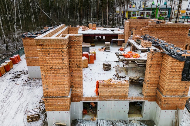 Draufsicht auf die Baustelle Bau eines roten Backsteinhauses Bauen im Winter Detailaufnahme der Baustelle Schnee auf der Baustelle