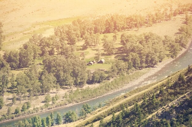 Draufsicht auf die kleinen Häuser des Flusses und das Bergtal getönt