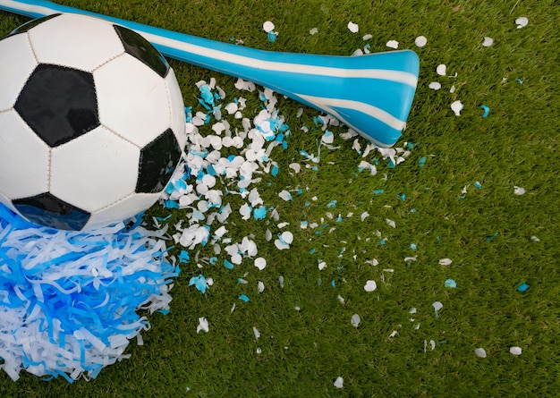 Draufsicht auf einen Ball, eine Vuvuzela und hellblaue und weiße Gastgeschenke