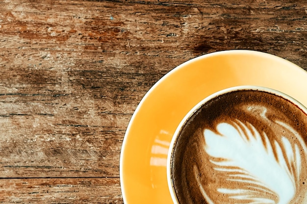 Draufsicht auf einen Latte-Art-Kaffee auf altem Holztisch