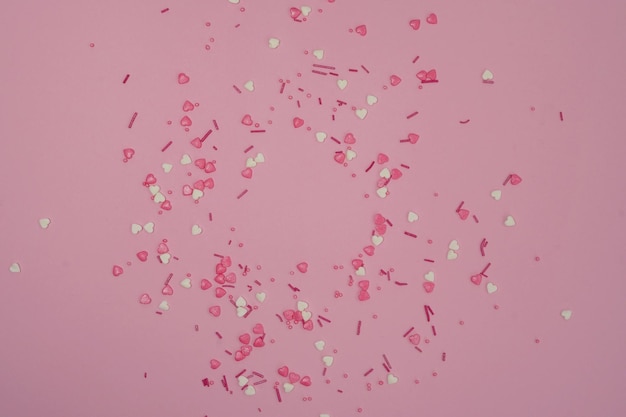 Draufsicht auf einen rosa weißen bunten Sprinkle auf einem rosa Hintergrund