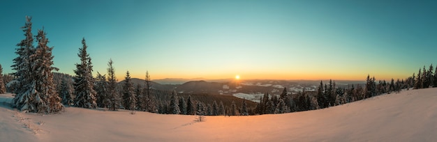 Draufsicht auf einen schönen faszinierenden Blick auf die Skipiste mit Skipisten in den Bergen an einem sonnigen Winterfrostabend. Urlaubs- und Tourismuskonzept im Winter.