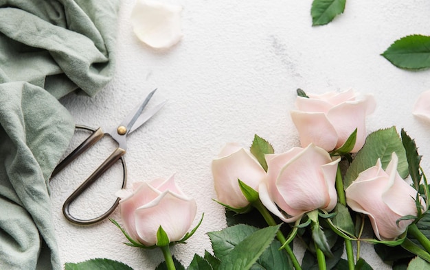 Draufsicht auf einen Strauß rosa Rosen, Schere und Stoff