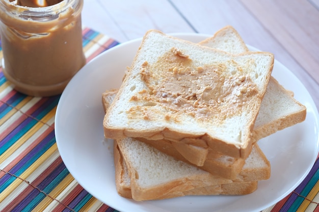 Draufsicht auf Erdnussbutter und Brotstapel auf dem Tisch