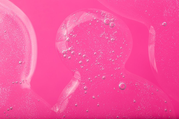 Draufsicht auf flüssiges Kosmetikgel mit sprudelnder Struktur auf rosa HintergrundGut als Kosmetikmodell
