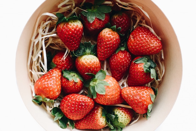 Draufsicht auf frische Erdbeeren in einer runden Holzkiste