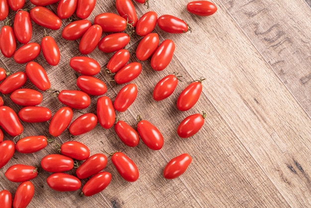 Draufsicht auf frische Kirschtomaten über Holztischhintergrund