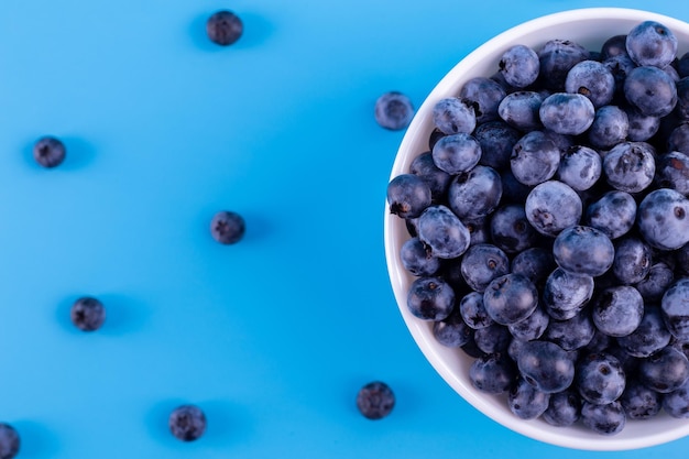 Draufsicht auf frische reife Blaubeeren in Schüssel auf Blau Gesunde natürliche Früchte Vegan und Vegetarier