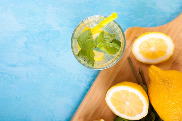 Draufsicht auf frisches Bio-Detox-Wasser mit Zitronen auf blauem Vintage-Holzhintergrund