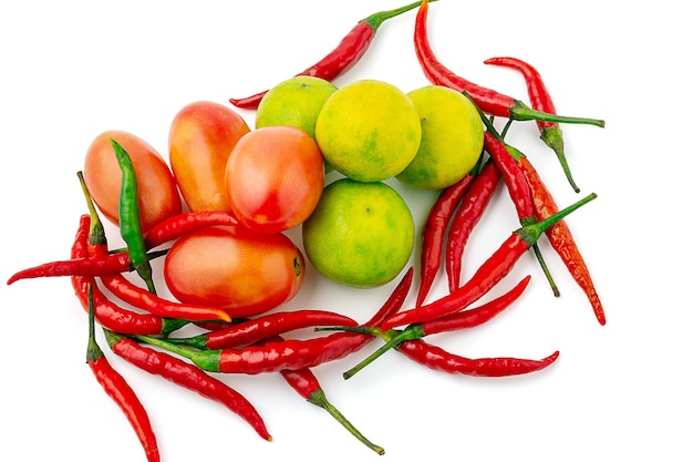 Draufsicht auf frisches Mischgemüse isoliert auf weißem Hintergrund, rote Chilis, Tomaten und grüne Zitrone. Gruppe thailändische Gewürze und Gemüse.