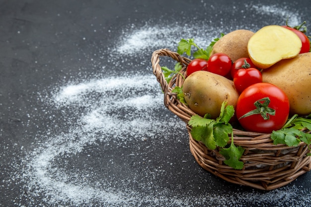 Draufsicht auf frisches rohes Gemüse und Grün in einem Holzkorb auf der linken Seite auf einem schwarz-weißen Hintergrund