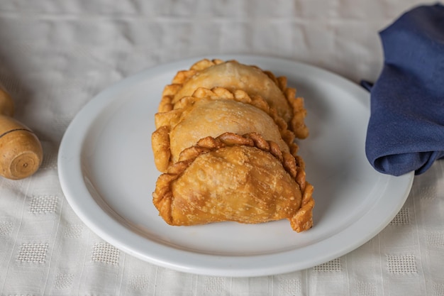 Draufsicht auf gebratene argentinische Empanadas auf einem weißen Teller