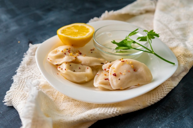 Draufsicht auf gekochte Teigtaschen mit Zitronen-Sahnesauce und grünen Kräutern