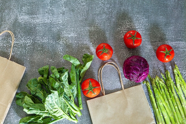Draufsicht auf Gemüse und Einkaufstüten, Gemüse und Getreide in einer Papiertüte auf schwarzem Hintergrund