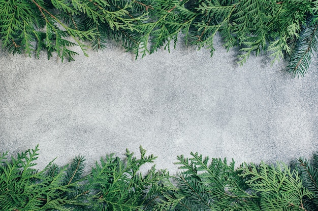 Draufsicht auf grauem Hintergrund mit Zweigen eines Weihnachtsbaumes