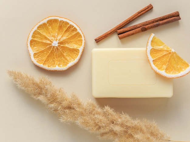 Foto draufsicht auf handgemachte seife mit zimtstangen und getrockneten orangenscheiben