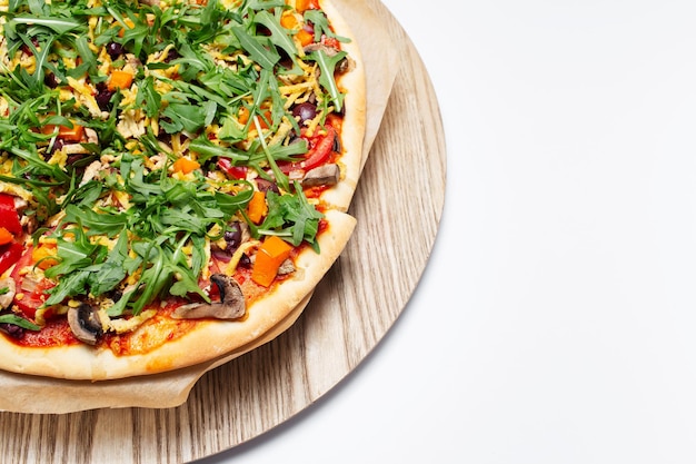 Draufsicht auf hausgemachte vegane Pizza auf Holzplatte auf weiß mit Kopierraum