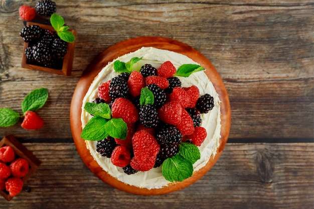 Draufsicht auf hausgemachten Beerenkuchen, dekoriert mit frischen Himbeeren und Brombeeren.