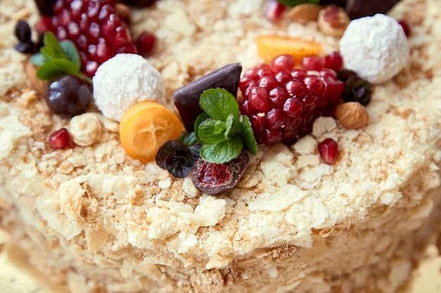 Draufsicht auf hellen hausgemachten Honigkuchen mit Früchten und Süßigkeiten