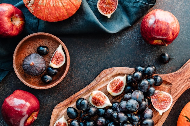 Draufsicht auf Herbstlebensmittel rote Äpfel, Feigen, Trauben und Kürbis