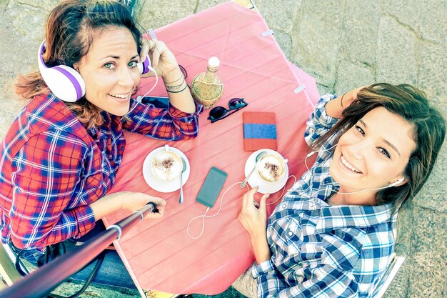 Draufsicht auf Hipster-Freundinnen, die ein Selfie mit Stock machen