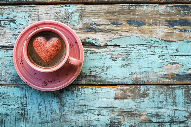 Draufsicht auf Kaffeetasse und Herzbogen