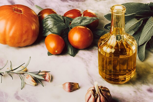 Draufsicht auf Olivenöl und frisches gesundes Gemüse auf Marmortisch