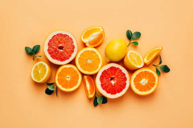 Foto draufsicht auf orangefarbene grapefour- und zitronenzitrusfrüchte mit kräutern auf gelbem hintergrund