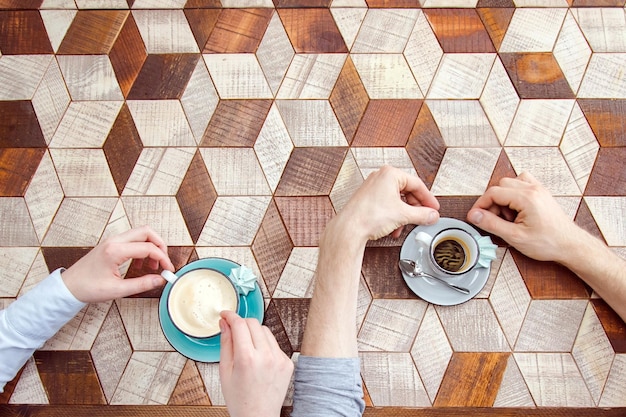 Foto draufsicht auf paarhände mit kaffee