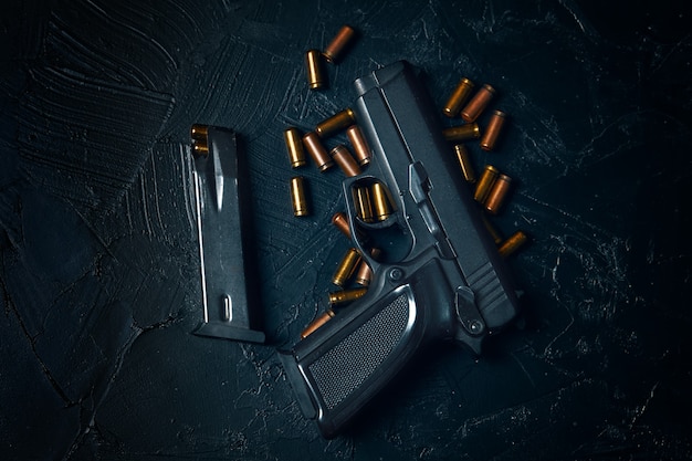 Foto draufsicht auf pistole und patrone mit kugelwaffen auf betontischpistole zur verteidigung oder angriffsko...