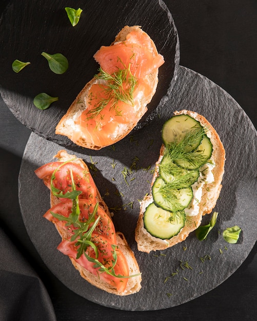 Foto draufsicht auf sandwiches mit tomaten, lachs und gurke