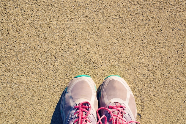 Draufsicht auf Schuhe auf tropischem Sandstrand Texturhintergrund, Kopienraum des Reiseabenteuerkonzepts.