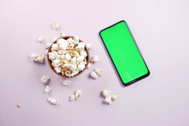 Draufsicht auf Smartphone und Popcorn auf dem Tisch