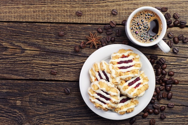 Draufsicht auf Tasse Kaffee und Kekse auf Holztisch