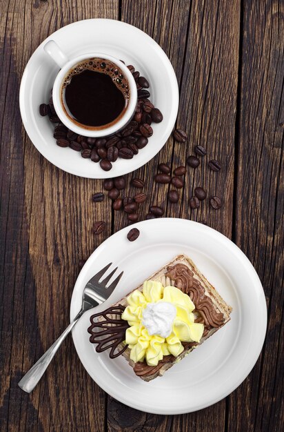 Draufsicht auf Tasse Kaffee und Kuchen auf Holztisch