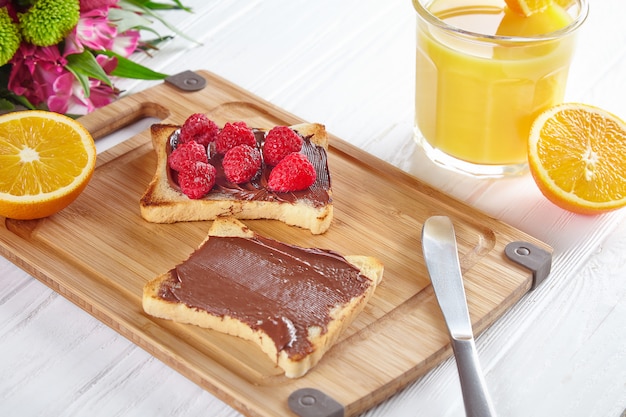 Draufsicht auf Toast mit Erdnussbutter, Himbeeren und Bananen