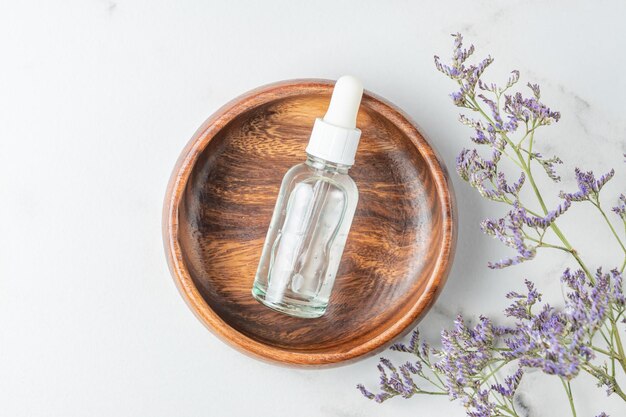 Draufsicht auf Tropfflasche mit Hyaluron-Kosmetikgel zur Hautbefeuchtung in Holzflasche Draufsicht Hautpflegekonzept Verpackung ohne Marke