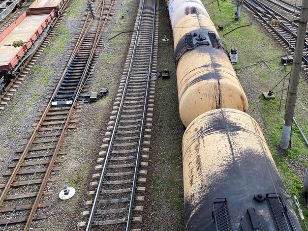 Draufsicht auf verschiedene Eisenbahnwaggons und Tanks auf einer Industriebahn mit Schienen