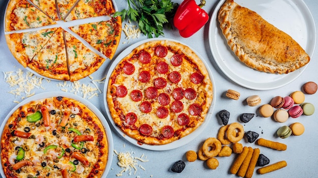 Draufsicht auf verschiedene Pizzen und Snacks auf einem Tisch