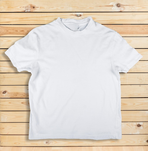 Draufsicht auf weißes T-Shirt auf Holzuntergrund