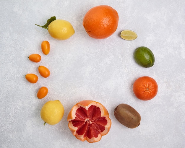 Draufsicht auf Zitrusfrüchte als Orangenlimette Kumquat Zitrone Kiwi Grapefruit auf weißem Hintergrund