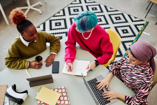 Draufsicht auf zwei Kreativteams von drei jungen Leuten, die ein Brainstorming-Projekt durchführen