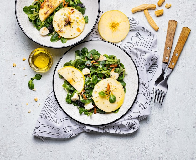 Draufsicht auf zwei Portionen Salat mit Spinat, Apfel und anderen gesunden Zutaten