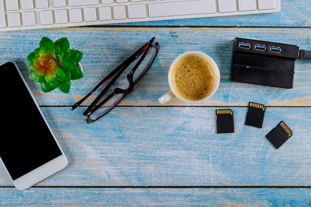 Draufsicht Brille und Kaffee, Laptop mit externer Festplatte, SD-Karte auf Fotografen Desktop Holztisch