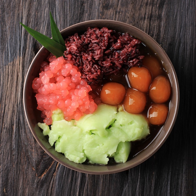 Draufsicht Bubur Madura, javanischer Dessertbrei aus Reismehlbrei (Bubur Sumsum), Süßkartoffelbällchen (Candil), Tapiokaperle und schwarzem Klebreis.