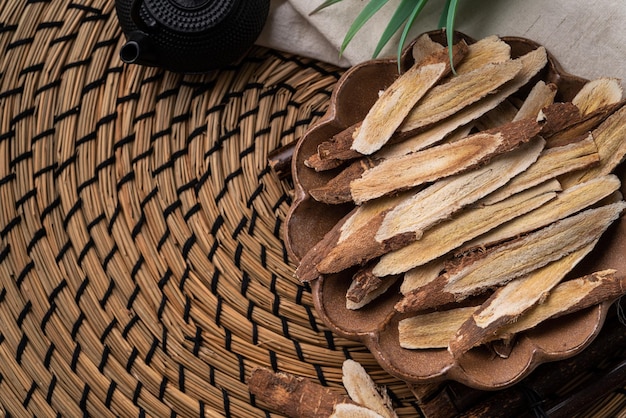 Draufsicht der chinesischen traditionellen Kräutermedizin Astragaluswurzel auf Holztischhintergrund.