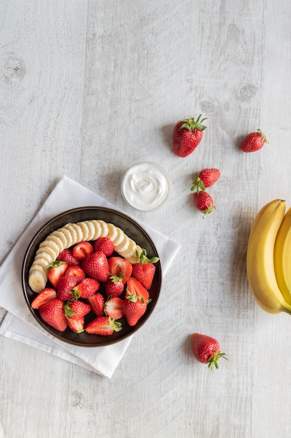 Draufsicht der Erdbeeren und der Banane diente mit Joghurt.